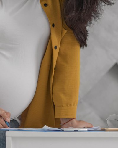 pregnant-woman-working-from-home-with-clipboard-pen